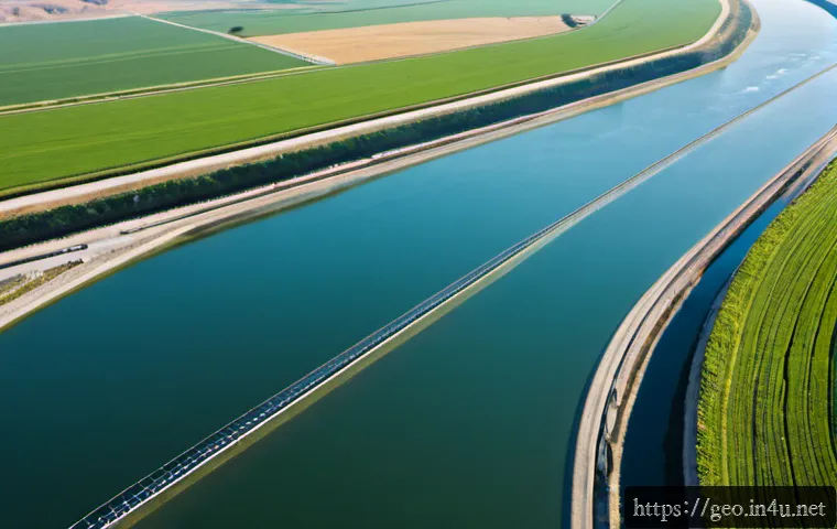 Home 17 지리학적 수자원 관리 - Photorealistic aerial view of a geographic water resource management landscape, a winding river feed...